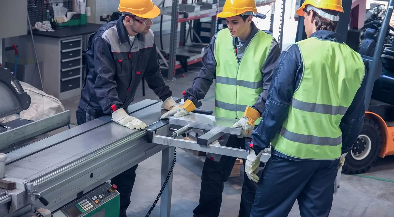 Workers operating CNC machinery at a metal fabrication shop