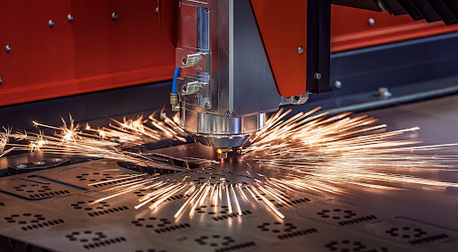 Laser cutting machine cutting metal sheet, with sparks flying